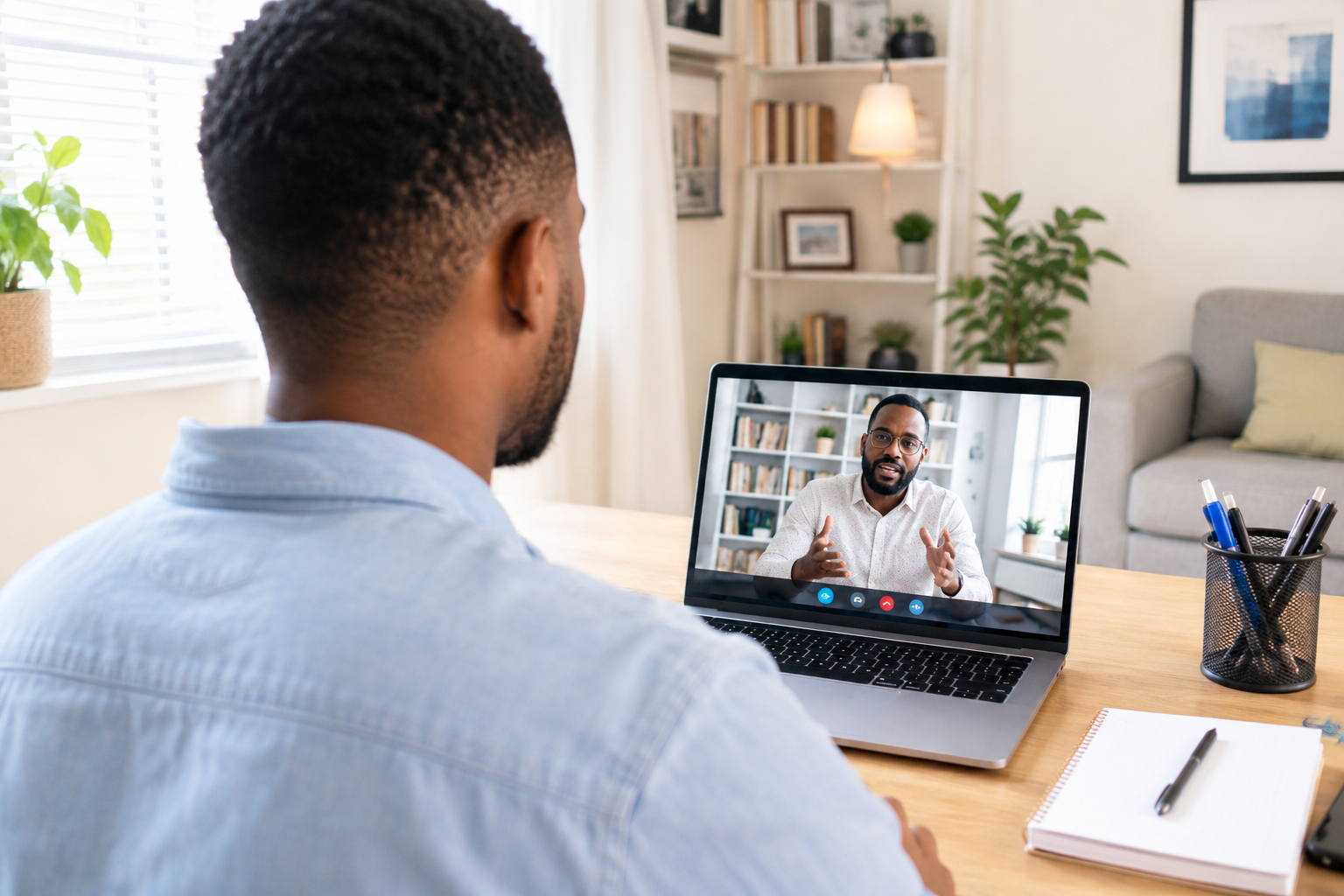 Homme en téléconsultation avec son psychologue depuis son bureau